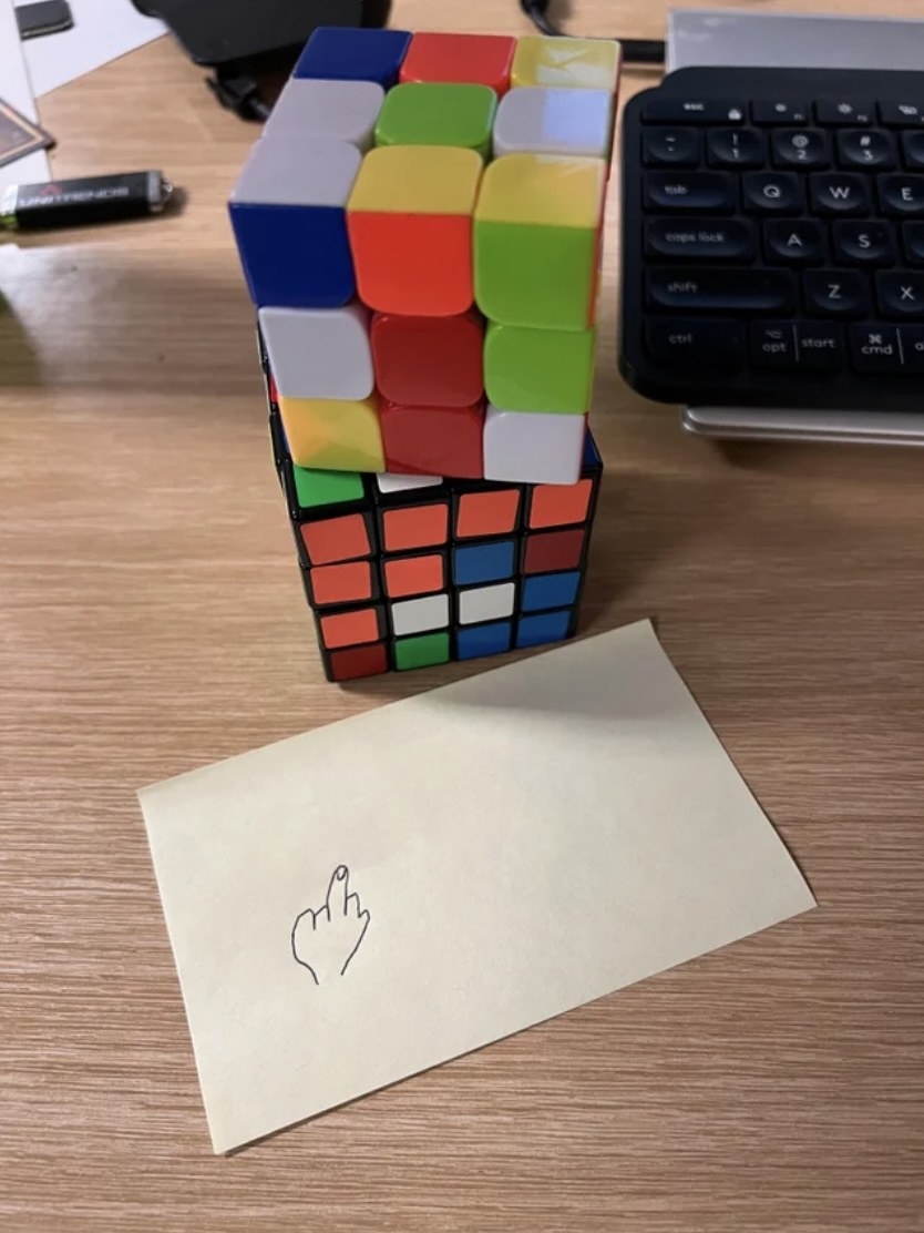 rubiks cube undone and a drawing of a middle finger
