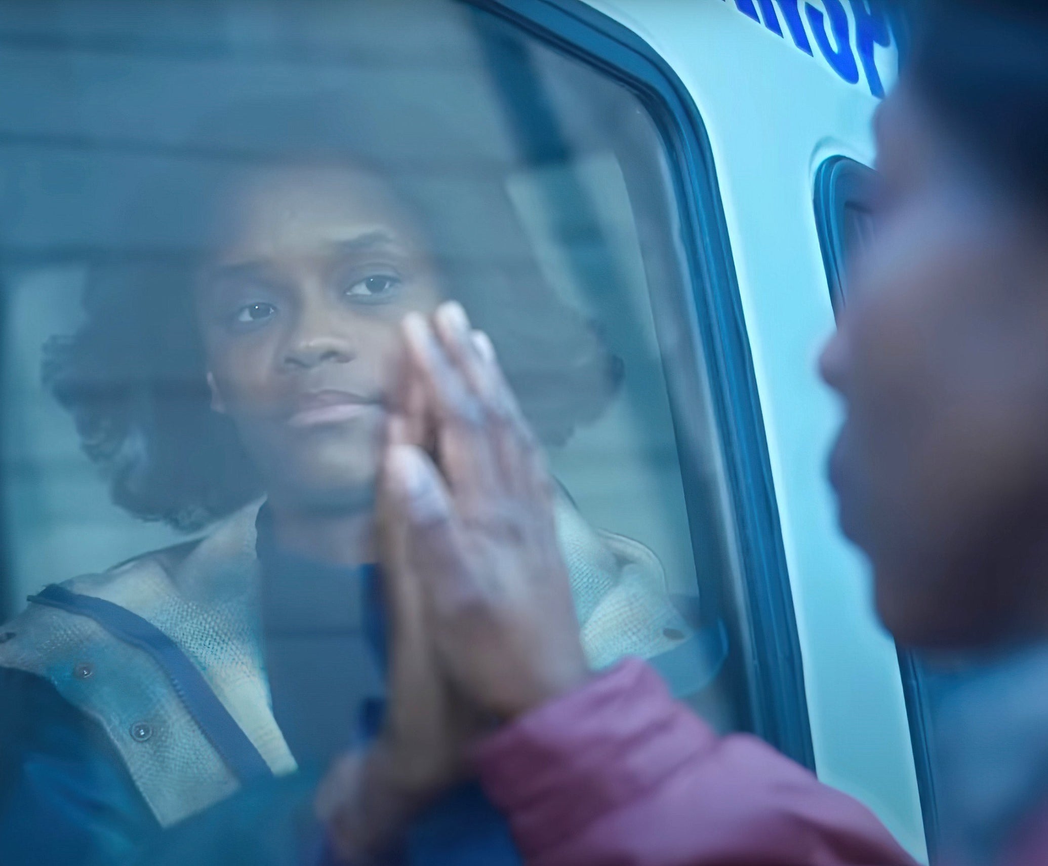 Letitia Wright in The Silent Twins sitting in a car with her hand up to the window