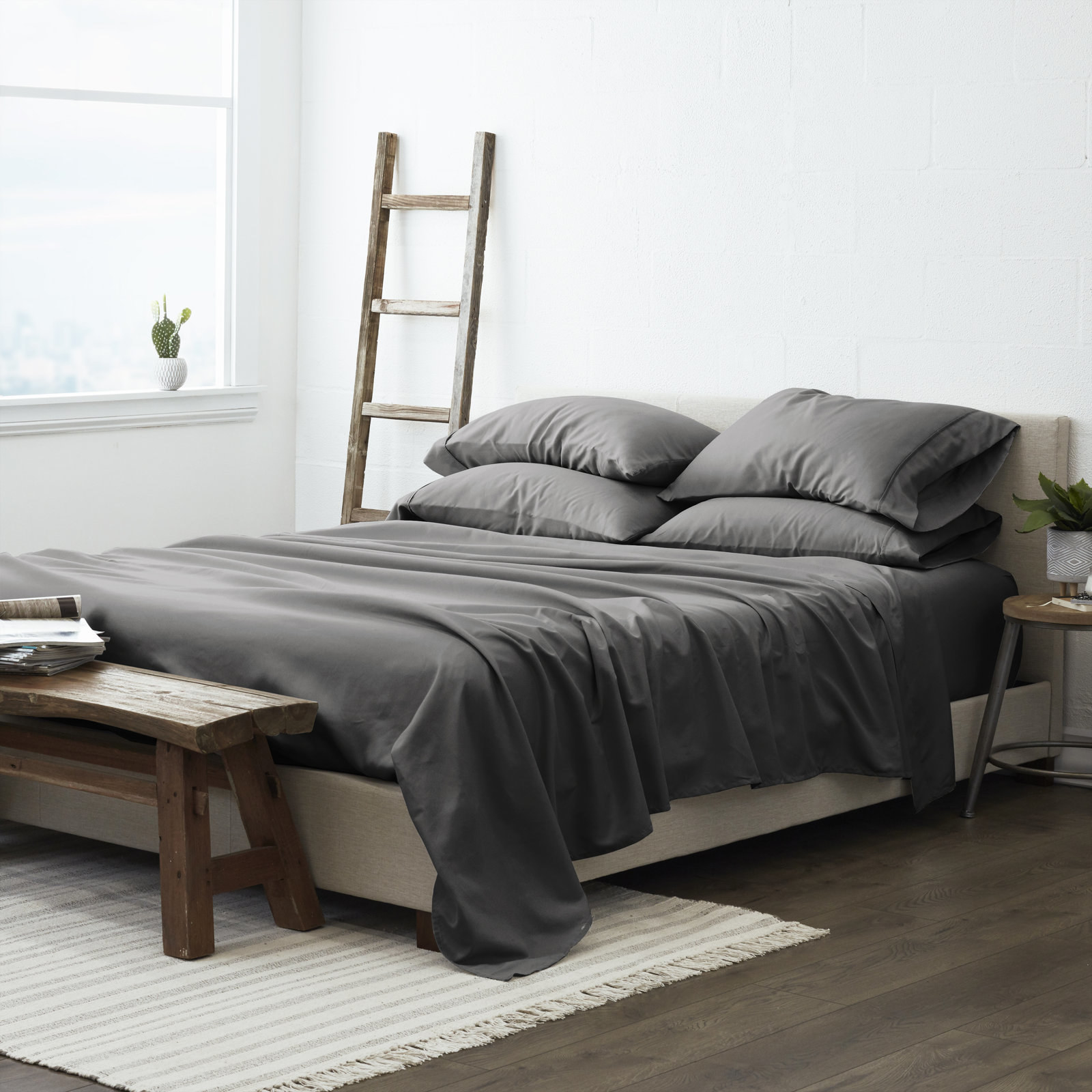 A bed with gray sheets