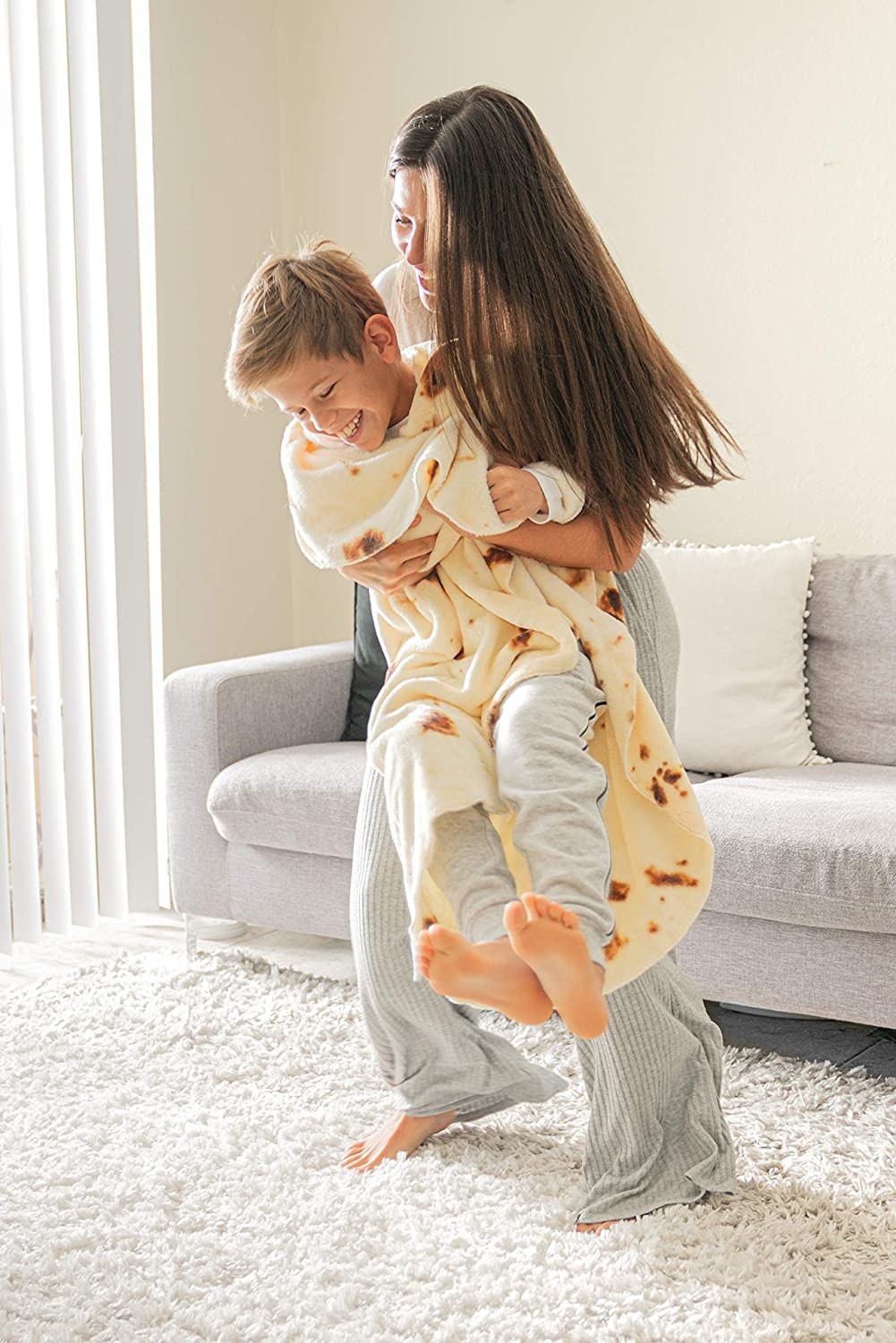 person hugging a child that's wrapped in the blanket