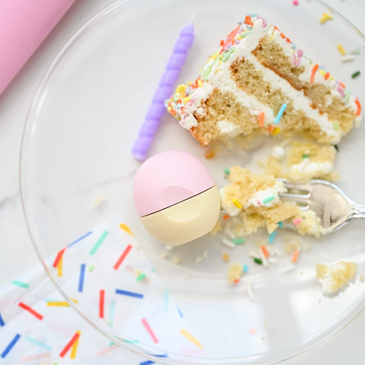 a lip balm on a plate next to birthday cake