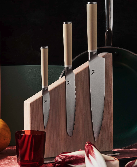 3 piece knife set next to red accent pieces.