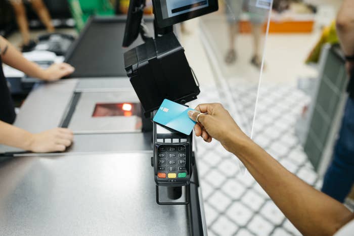 Close up of a female hand paying with a credit card on a cashier machine