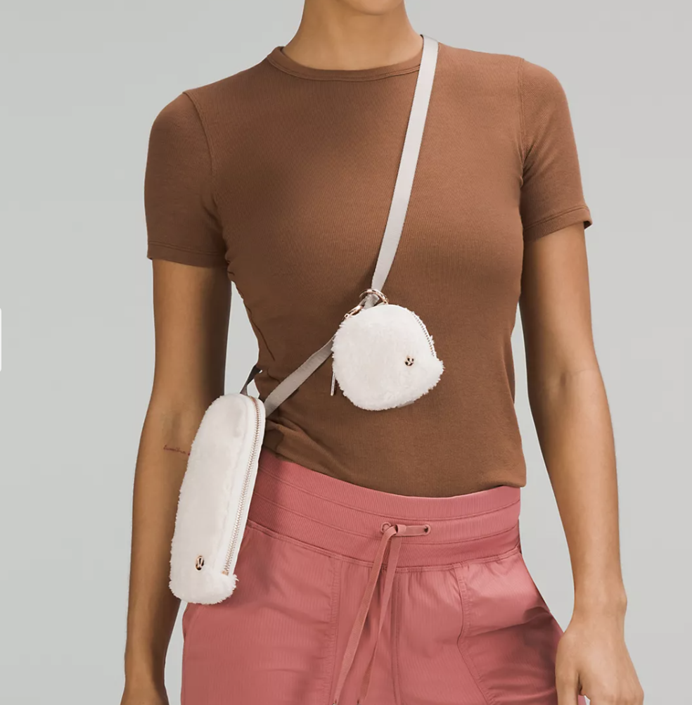 a person wearing the crossbody pouch in front of a plain background