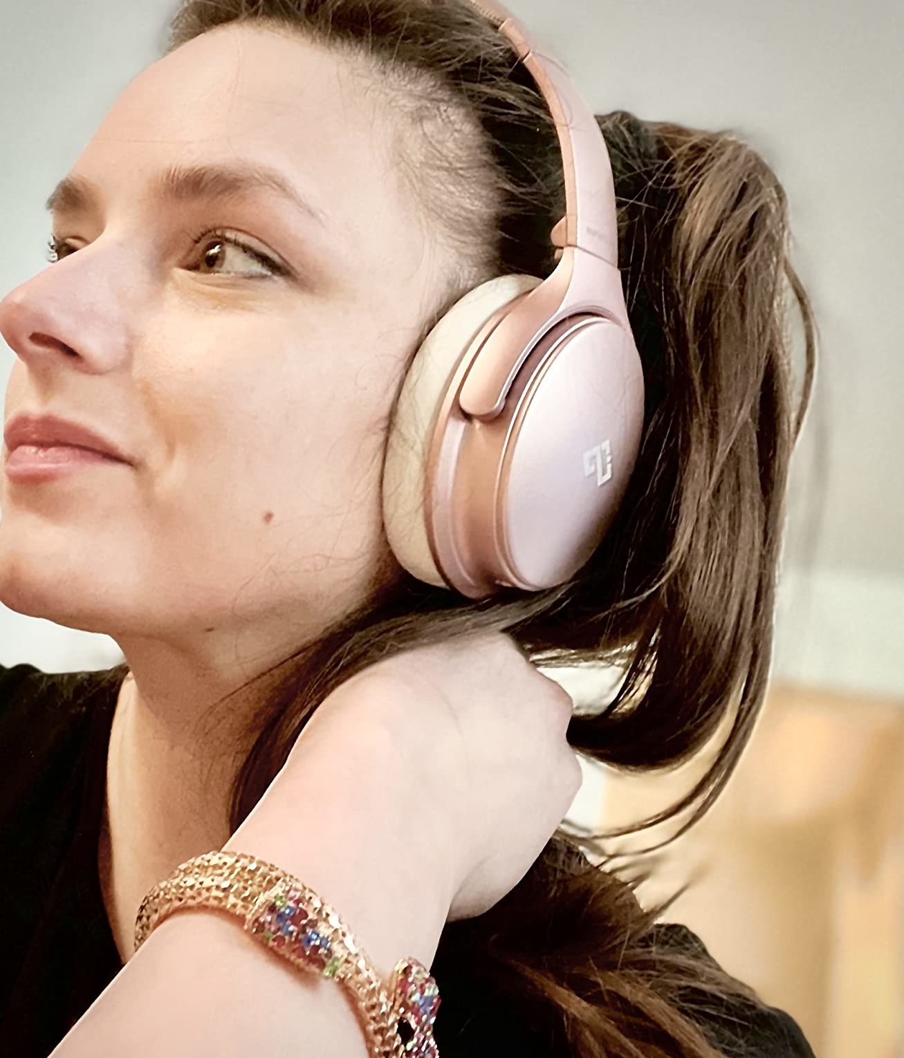 Reviewer&#x27;s photo of a person wearing the headphones in the color Rose Gold