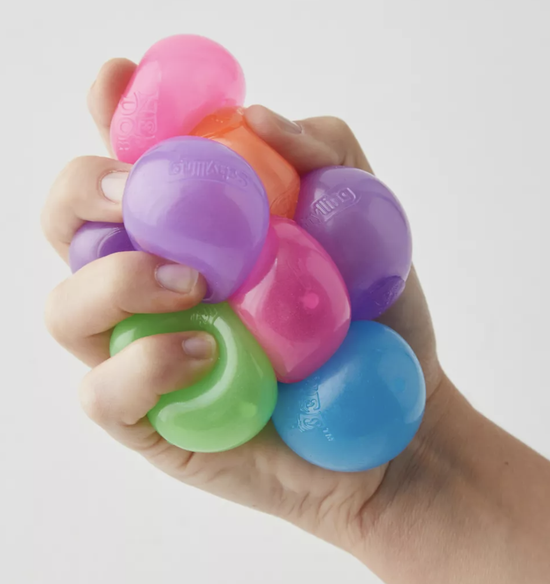 a person&#x27;s hand holding a bunch of the fidget balls