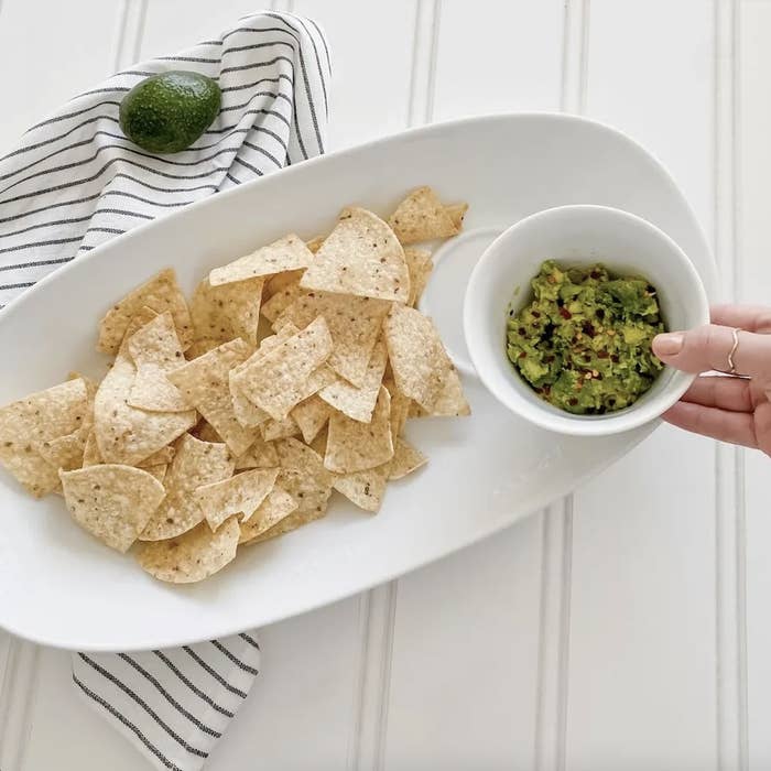 tortilla chips in the plate and guacamole in the bowl