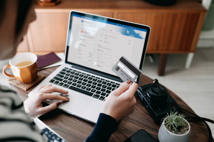 Person at a laptop and holding a credit card