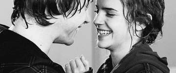 Ron and Hermione smiling and laughing at each other in black and white