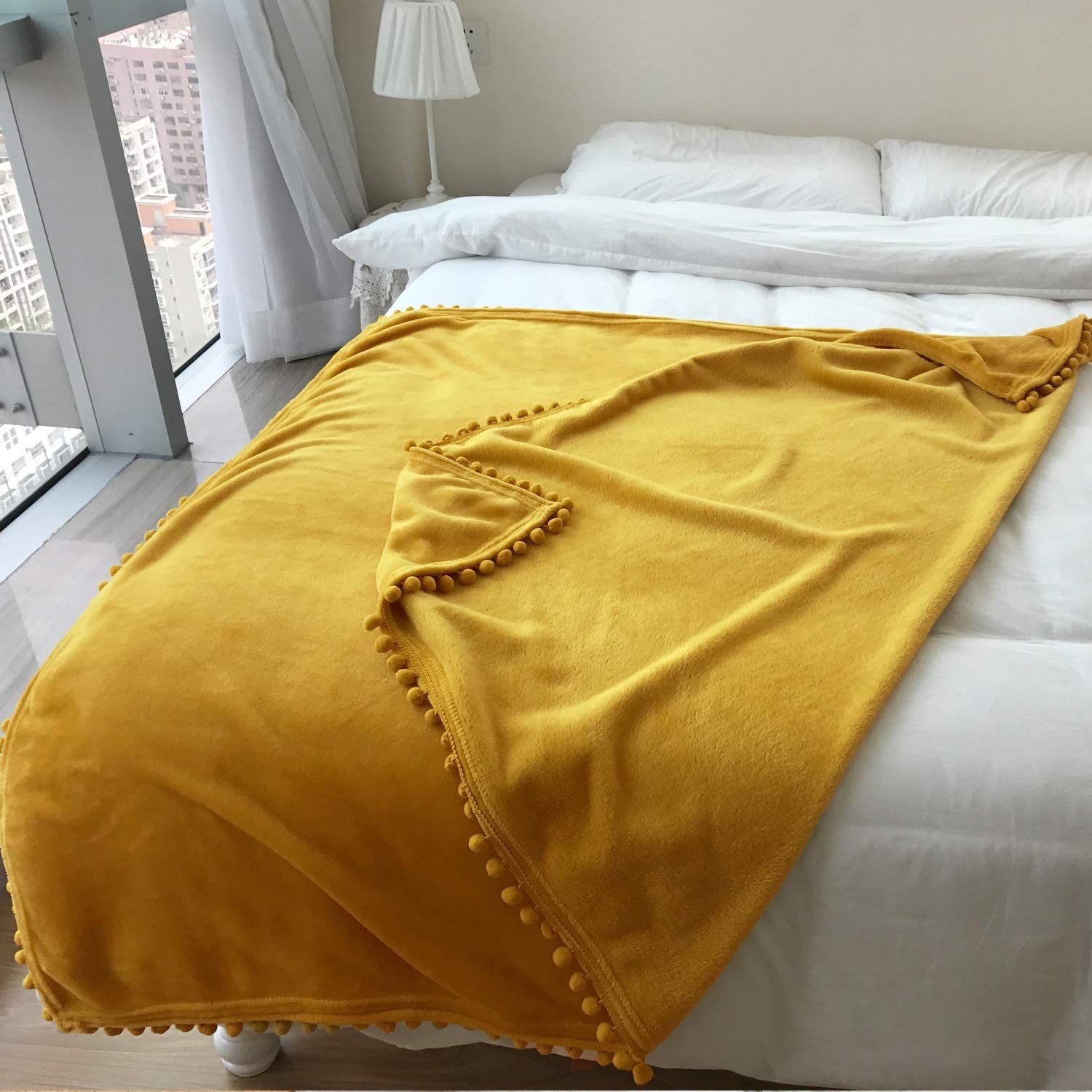 the mustard blanket on a white bed