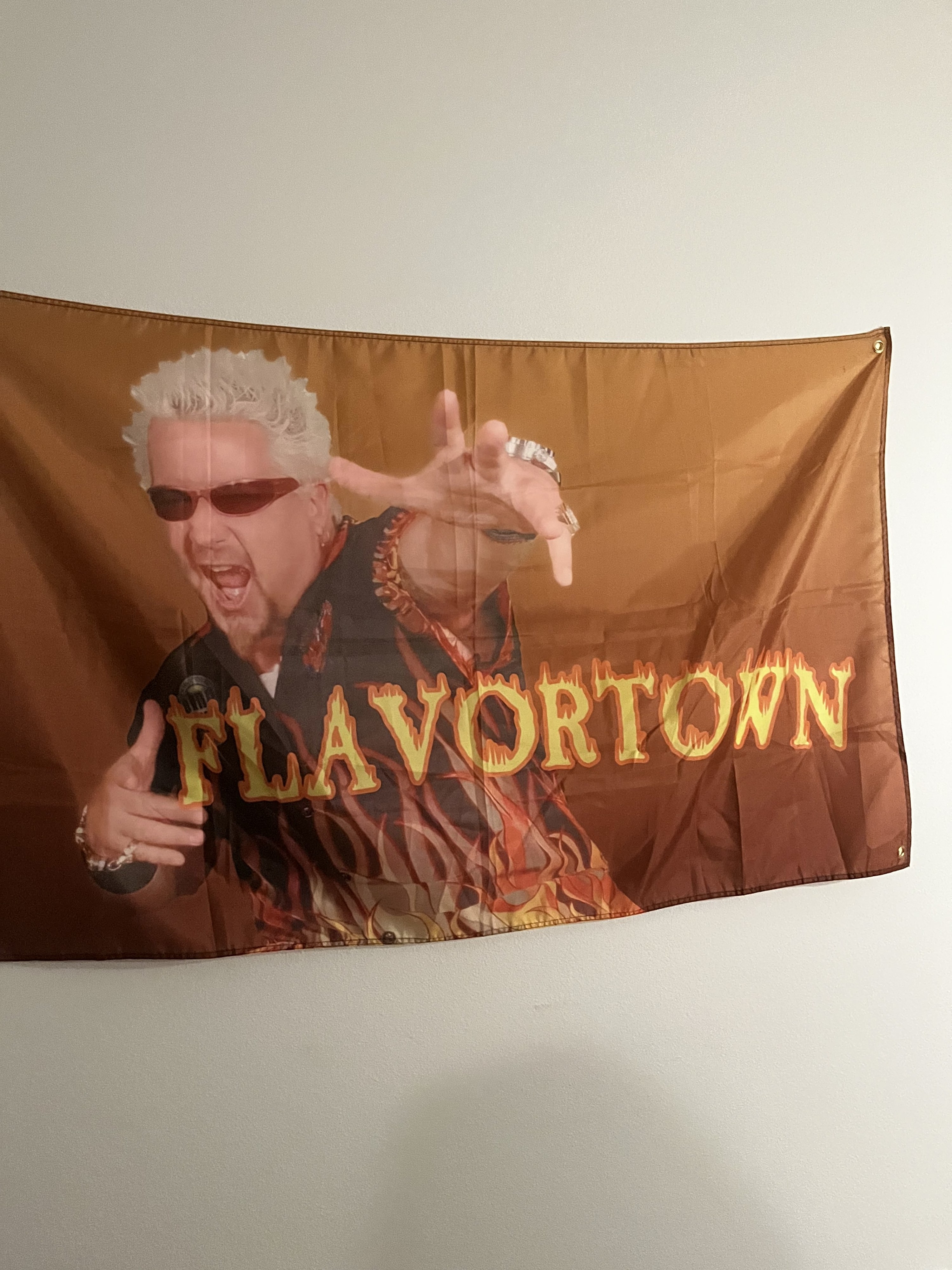 A flag of Guy Fieri that says &quot;Flavortown&quot;