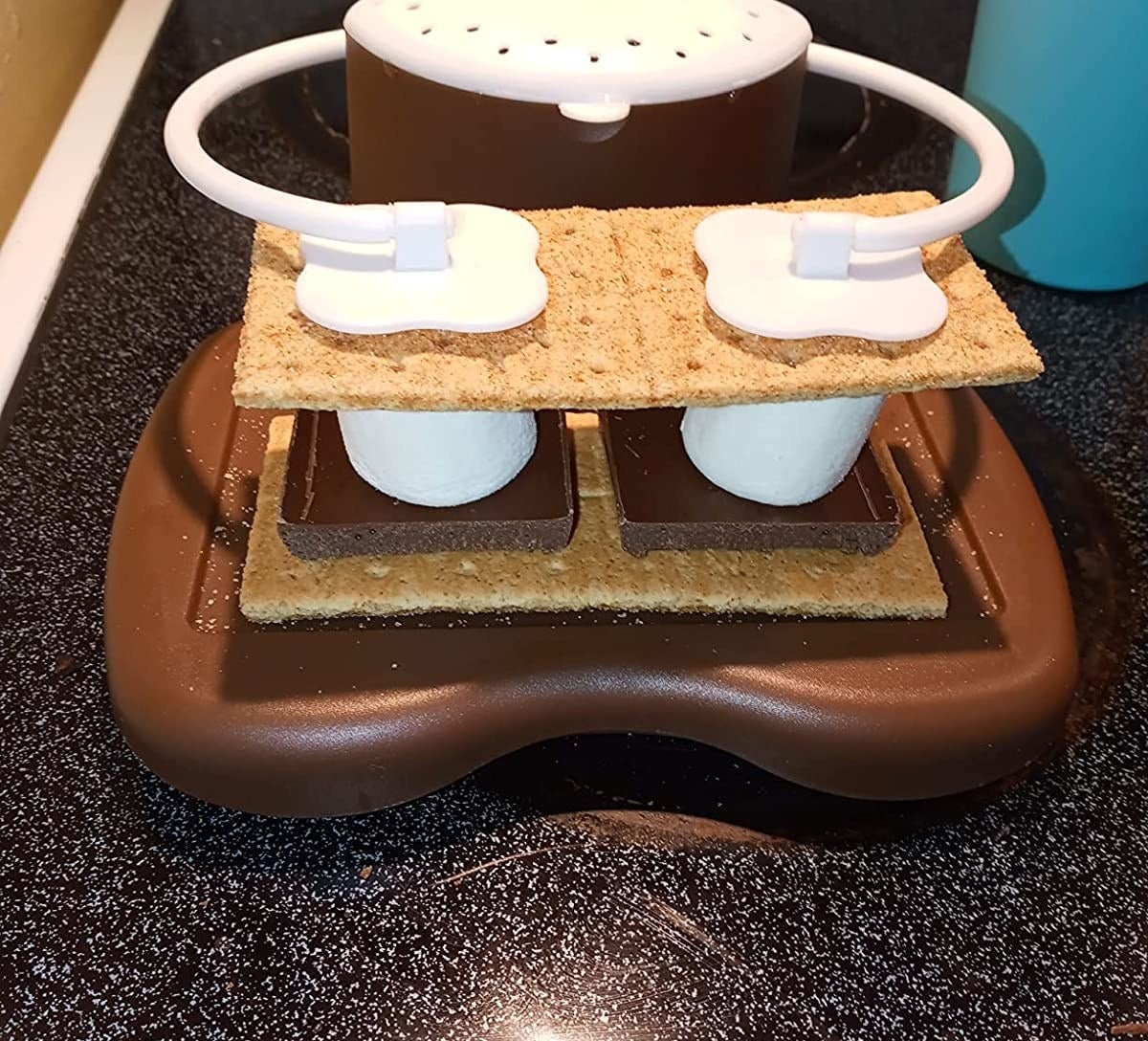 The s&#x27;mores maker holding two s&#x27;mores on stove top