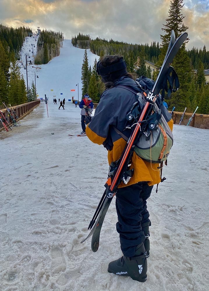 Reviewer using ski and pole carrier to hold skis at ski mountain