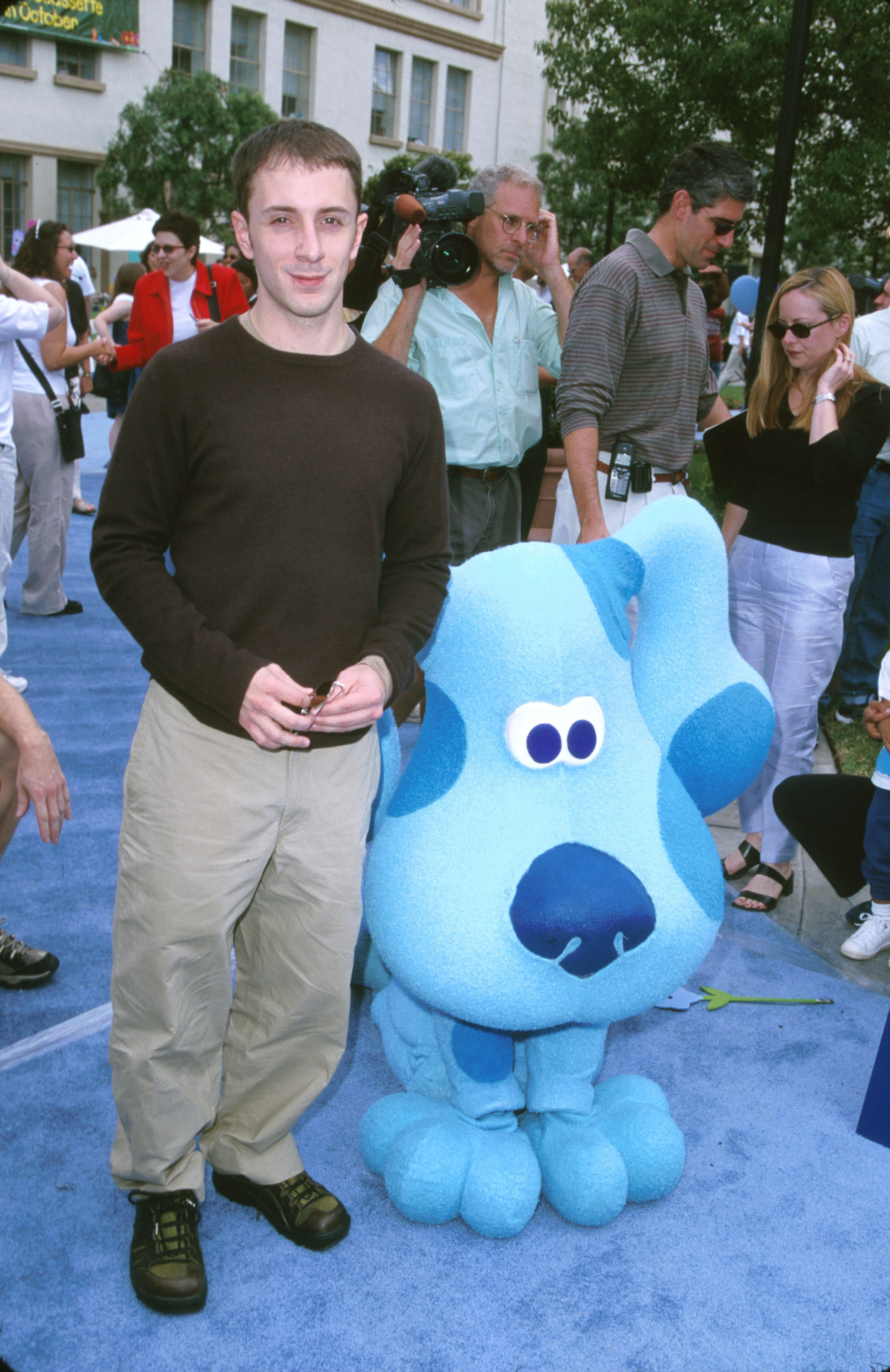 Steve on the blue carpet for an event standing next to an oversized plush version of Blue