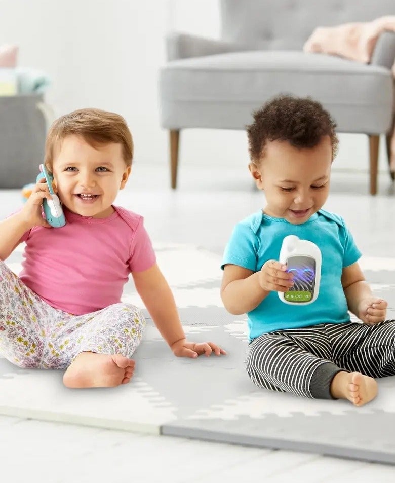 two toddlers playing with their own play phone