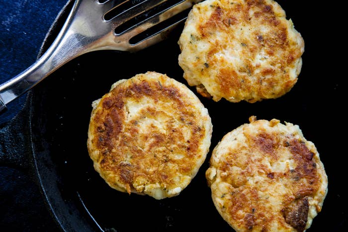 Fish cakes in a cast iron skillet.