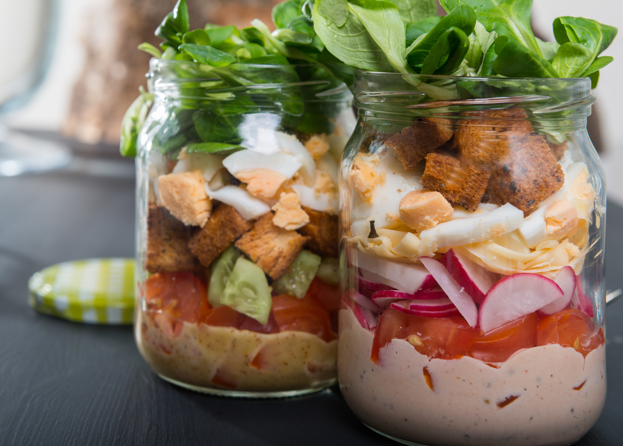 Two salads in mason jars.