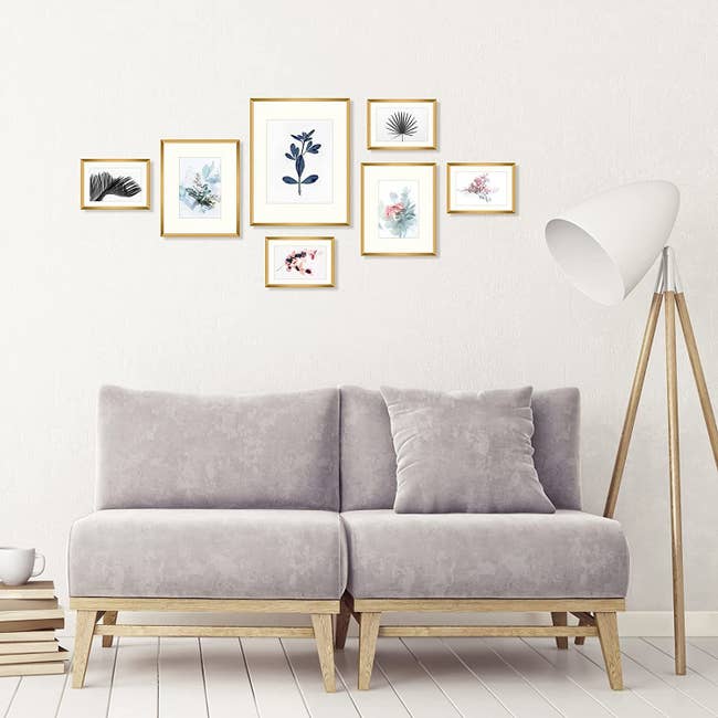 The frames on a wall behind a sofa