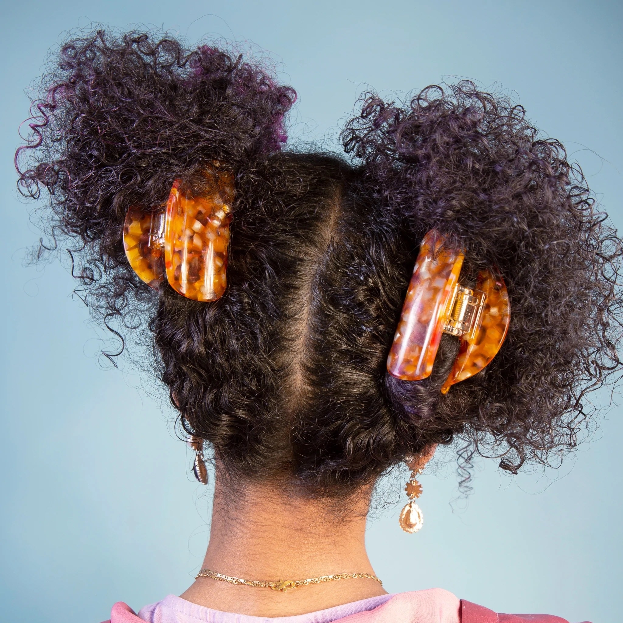 model wearing two speckled orange claw clips