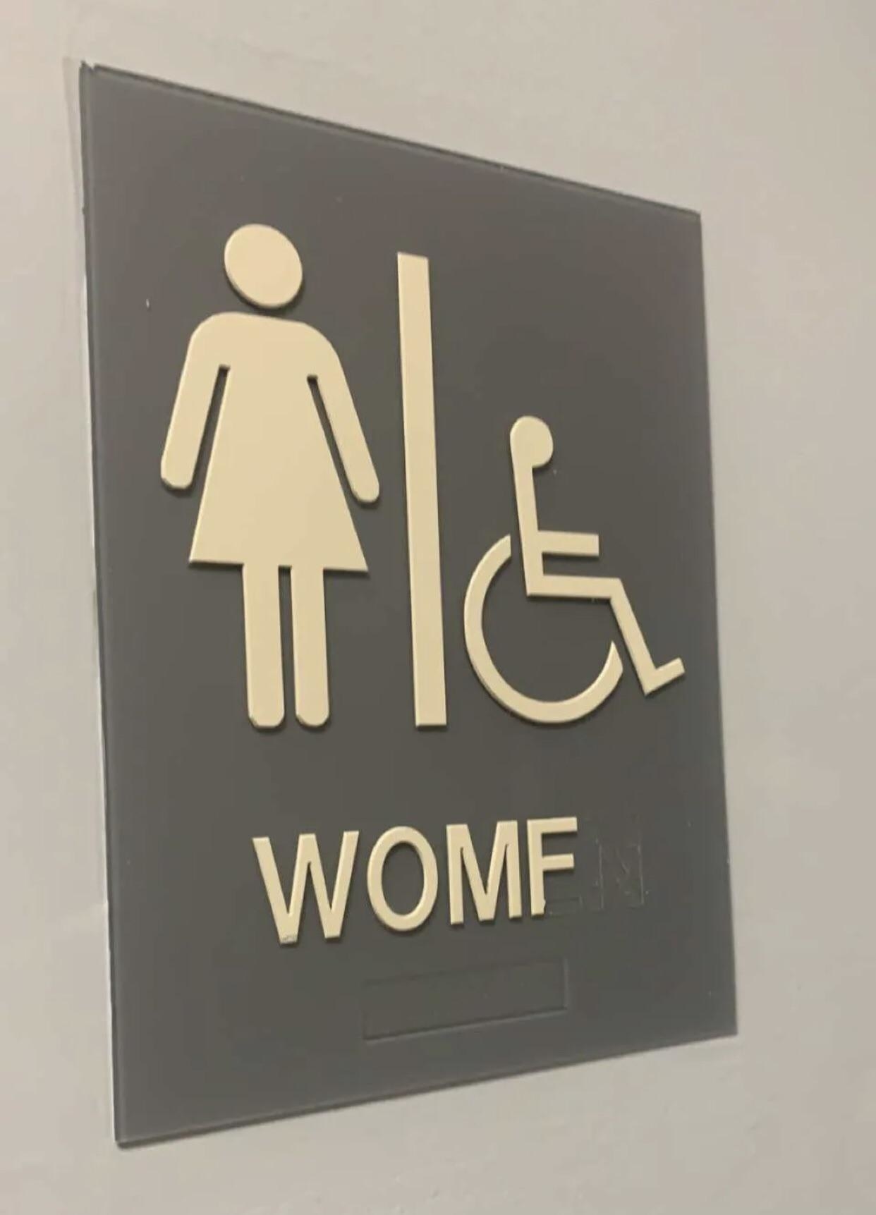women&#x27;s bathroom sign that reads womf