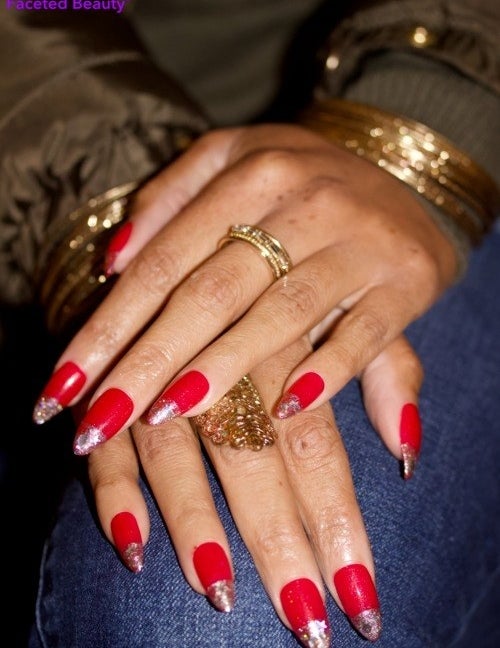 Model wearing red nails topped with gray glitter, placing their hands on denim jeans.