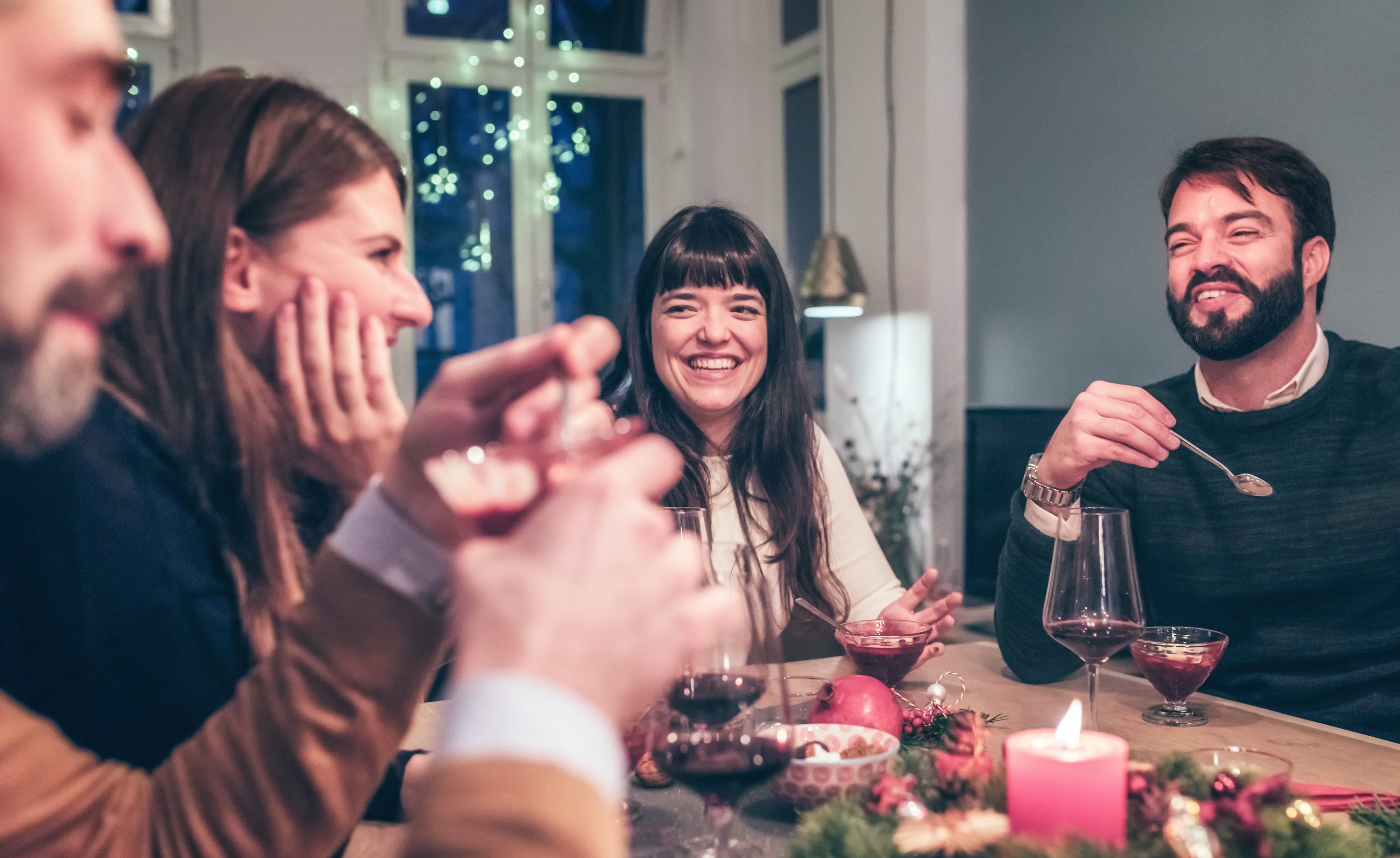 young happy people taking at Christmas table at night