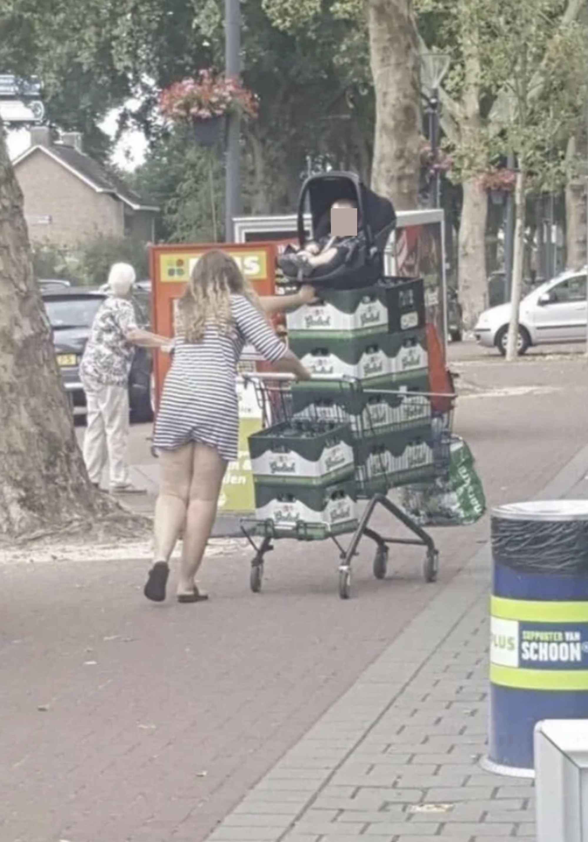 A woman with her baby&#x27;s car seat on a pile of beer