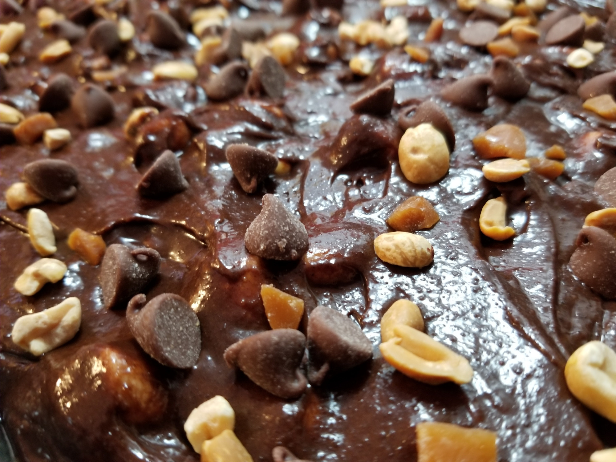 A brownie covered in nuts and chocolate pieces