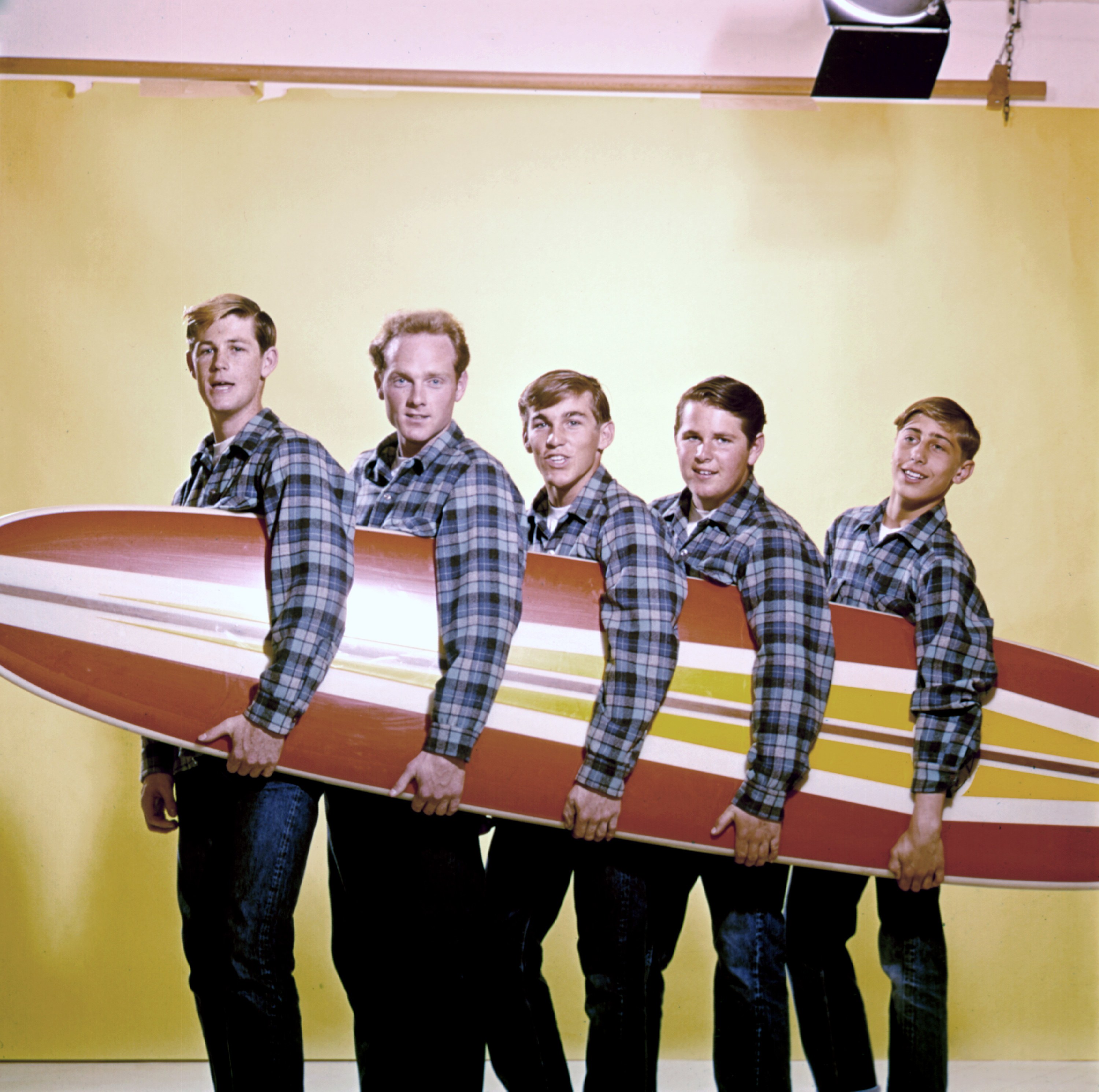 the group holding a surfboard