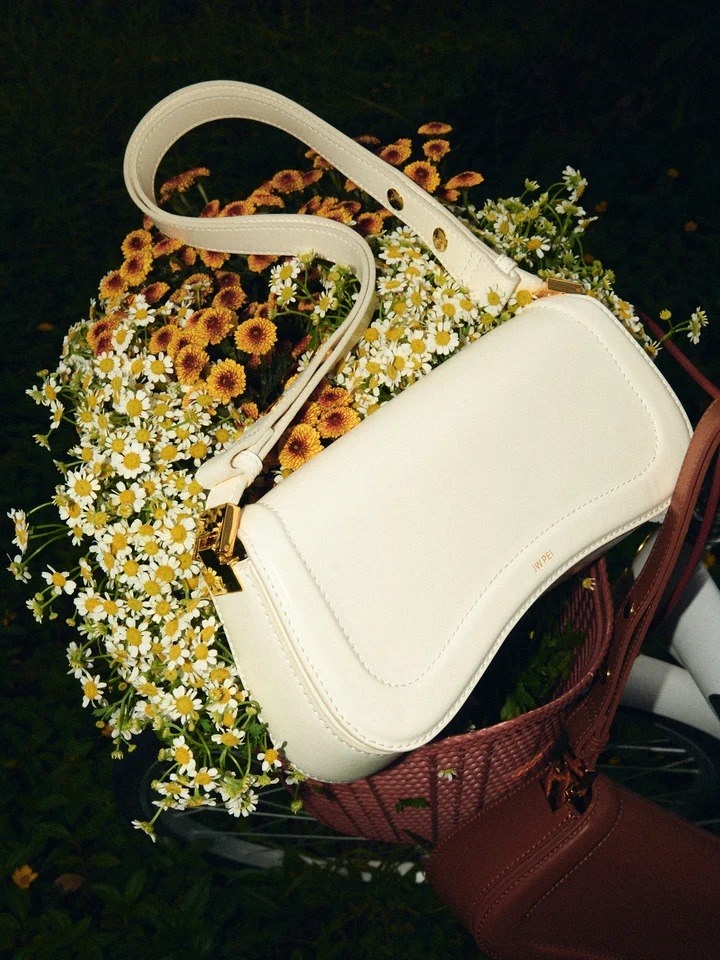 the white shoulder bag in a basket of flowers