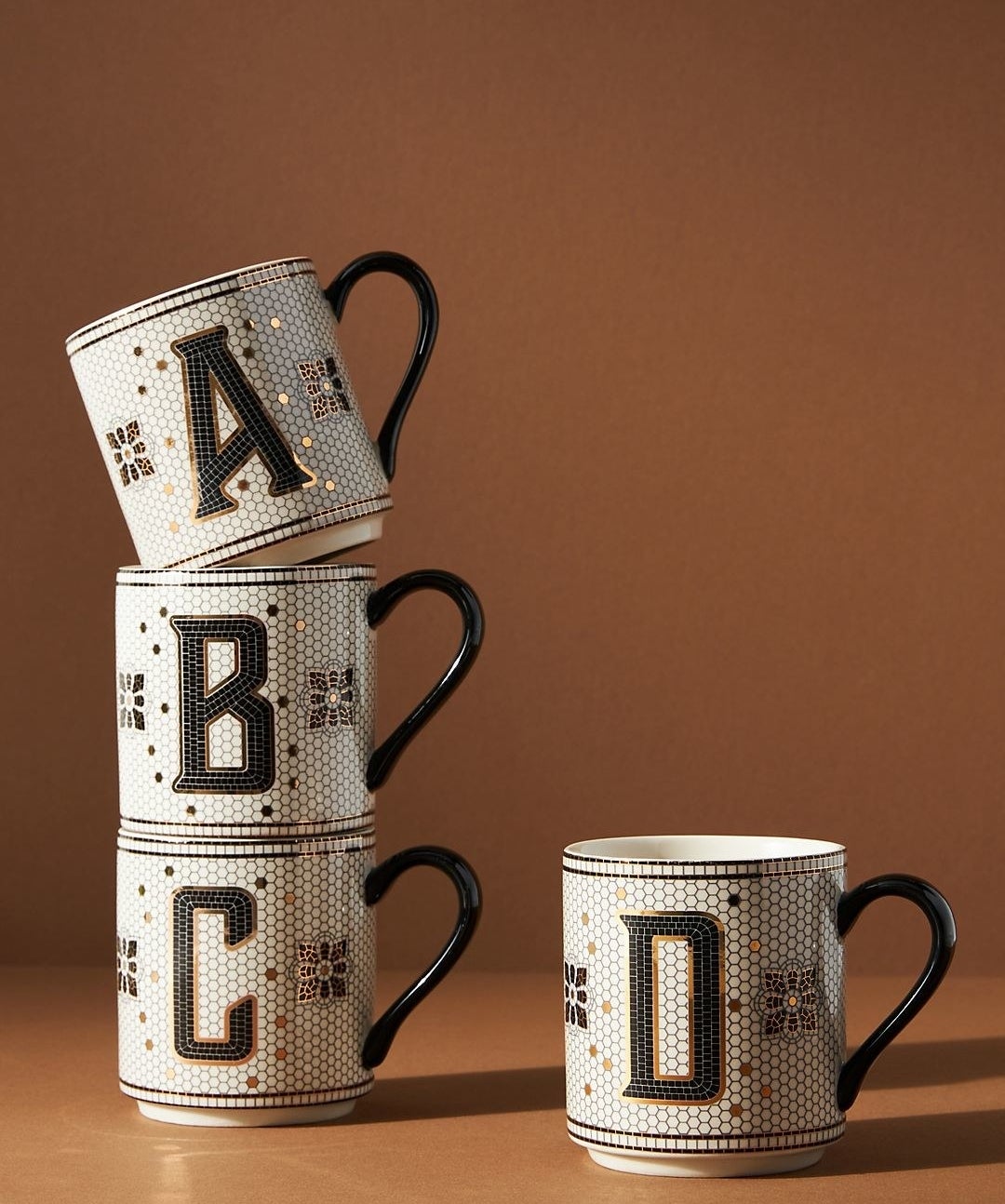 mugs monogrammed A, B, and C in a style that looks like black, white, and gold vintage tile