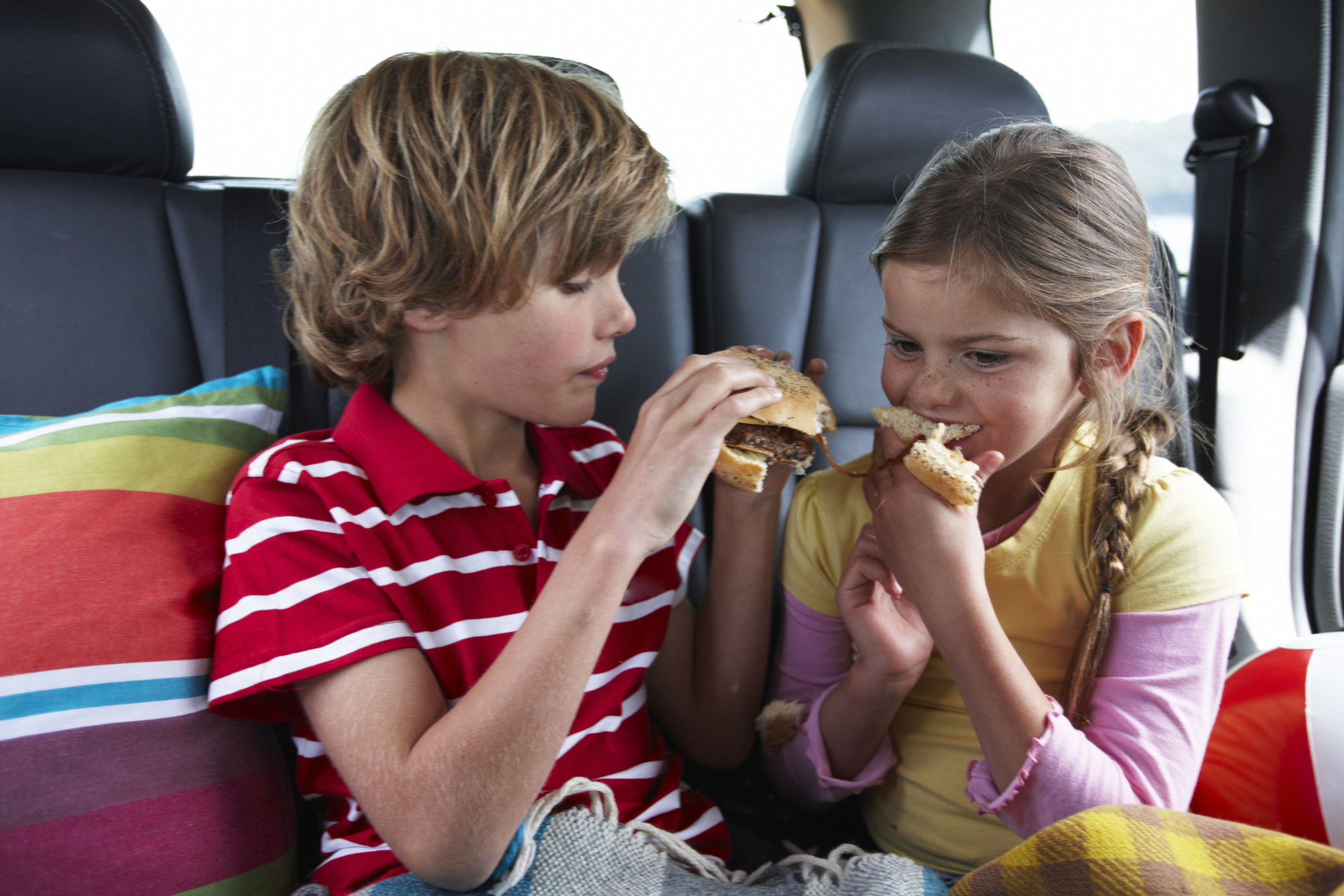 Two children sharing a burger