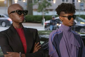 Okoye and Shuri stand side by side in dark sunglasses