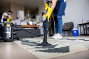 A person is vacuuming the carpet