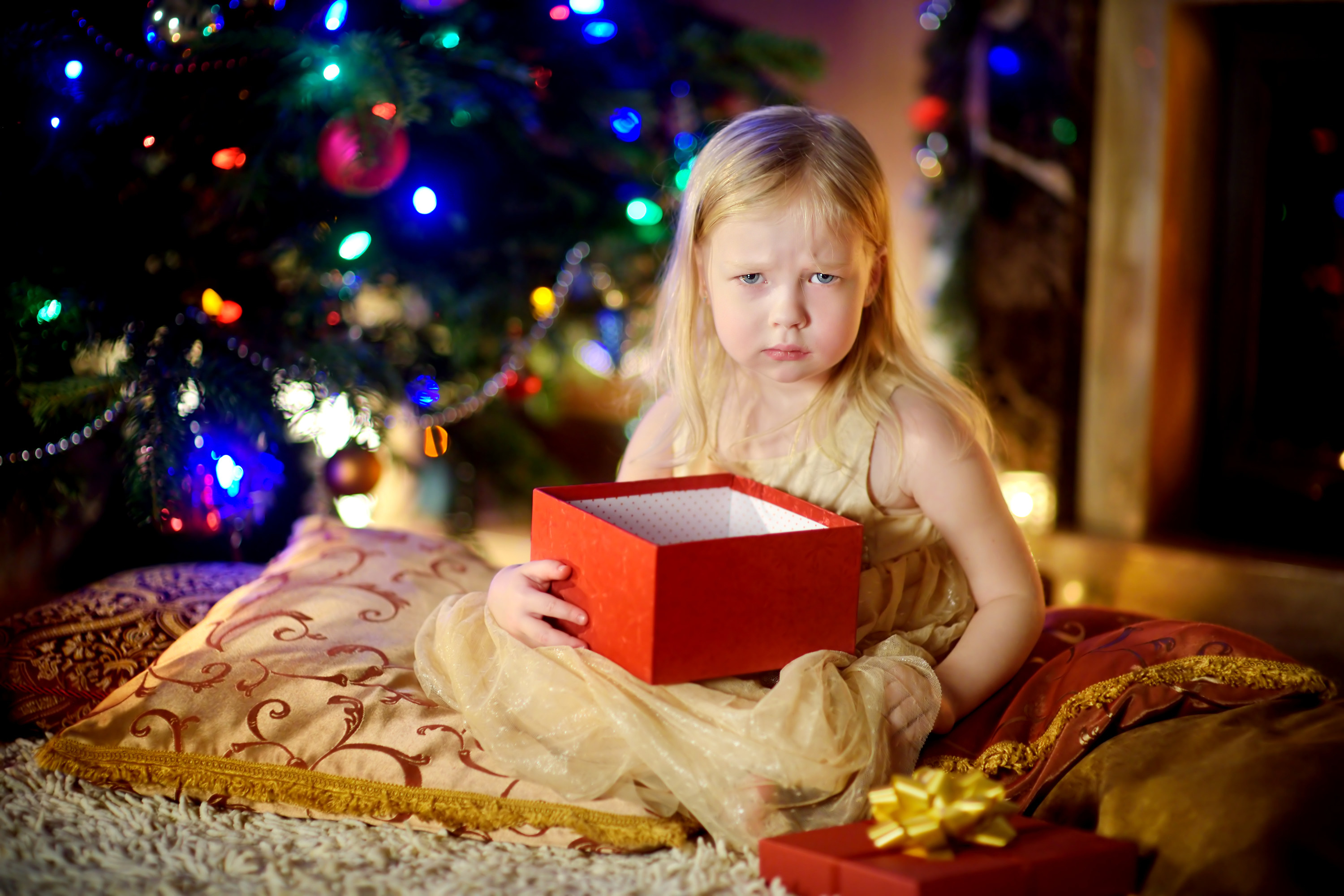 A little girl looking mad while holding an empty gift box
