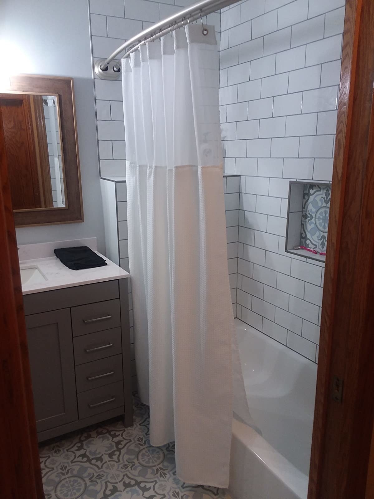 a reviewer photo of the white shower curtain in a decorated bathroom