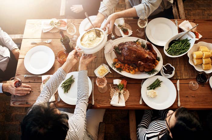 High angle shot mash being passed around during a feast at a dining table on Thanksgiving