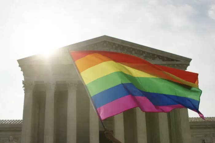 rainbow lgbtq flag waves in front of the supreme court