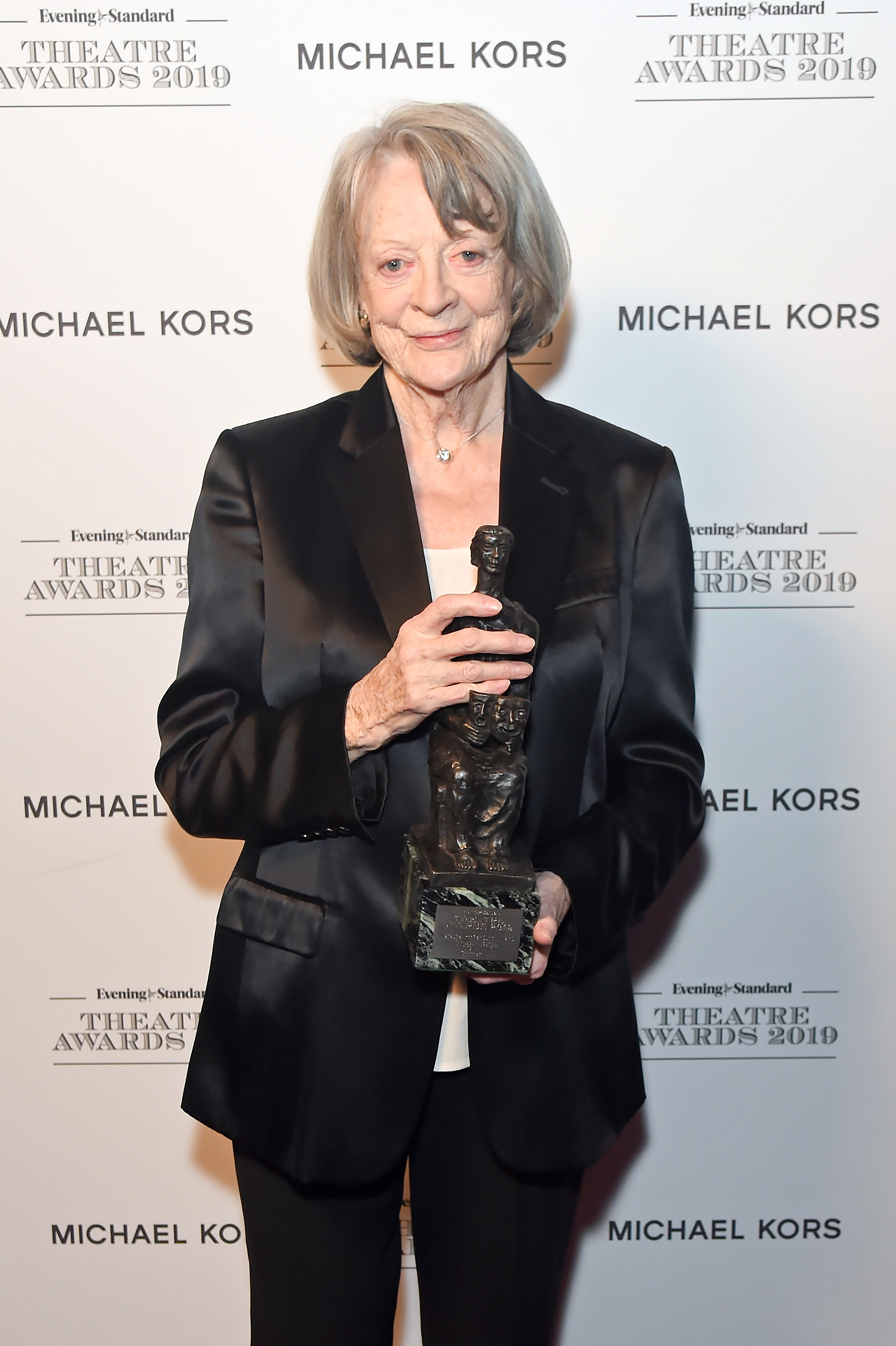 Maggie Smith holding an award at an event