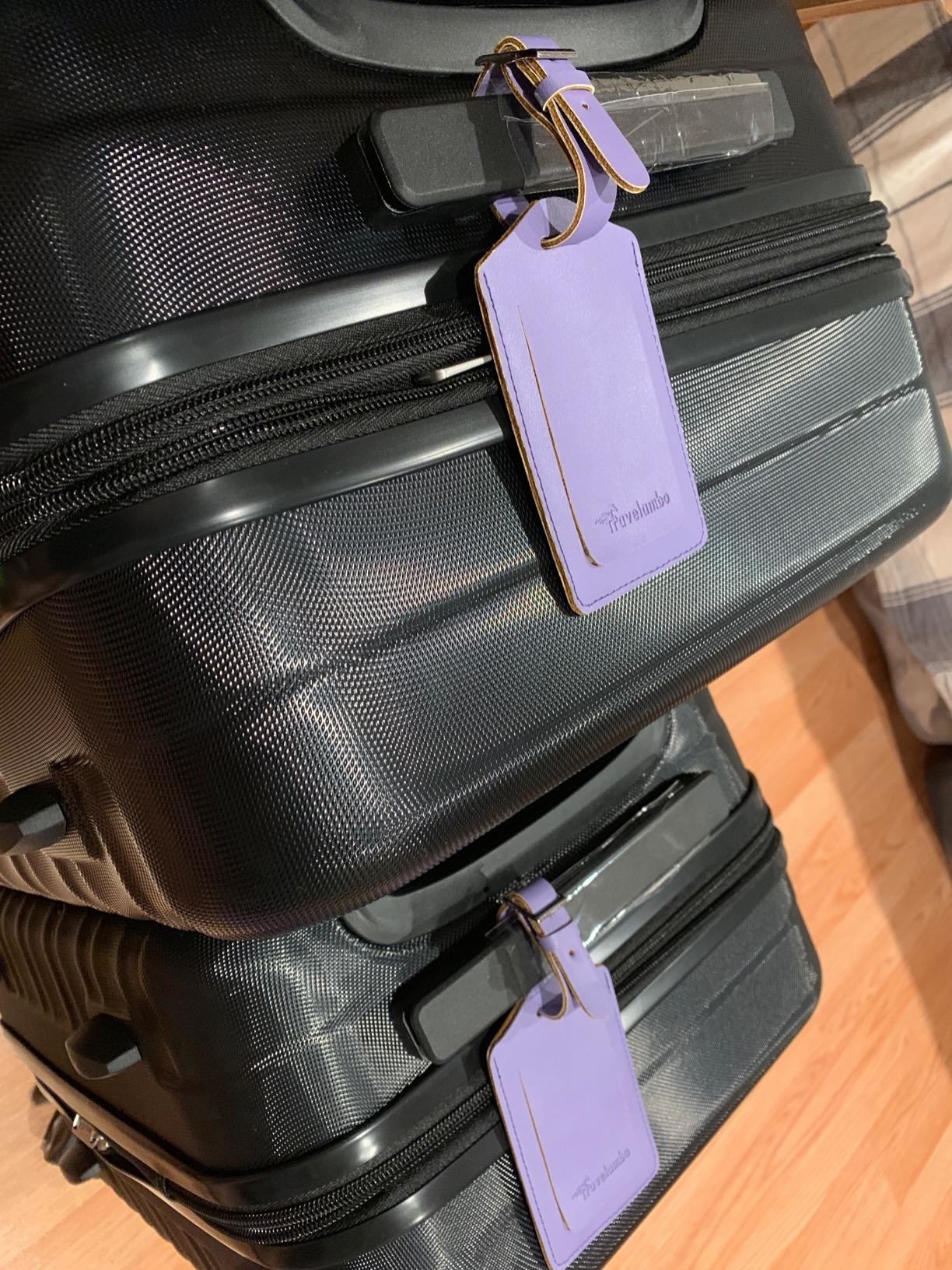 Purple luggage tags on two suitcases