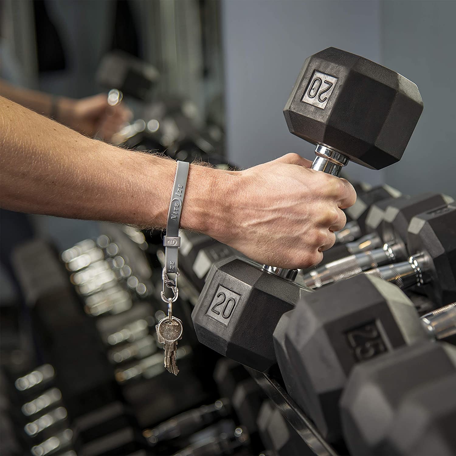 person lifting a dumbbell with the strap on their forearm