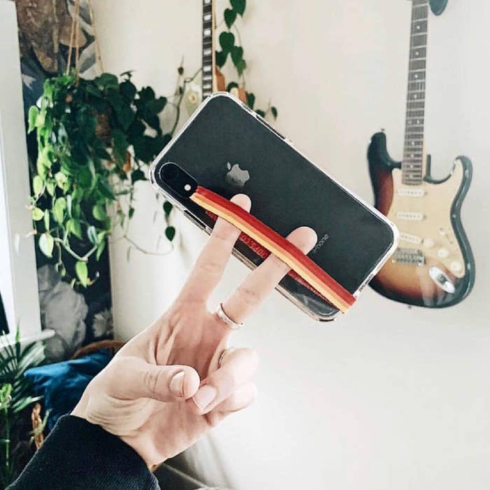 A person holding the phone loop with their two fingers
