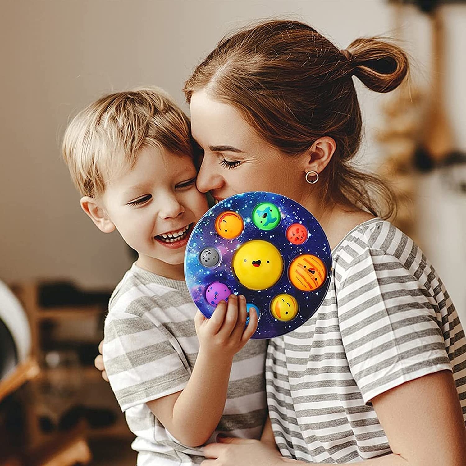 child holding the planet bubble popper with parent hugging them
