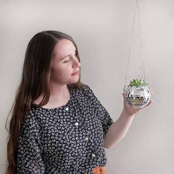 A model next to the hanging planter with mini succulent
