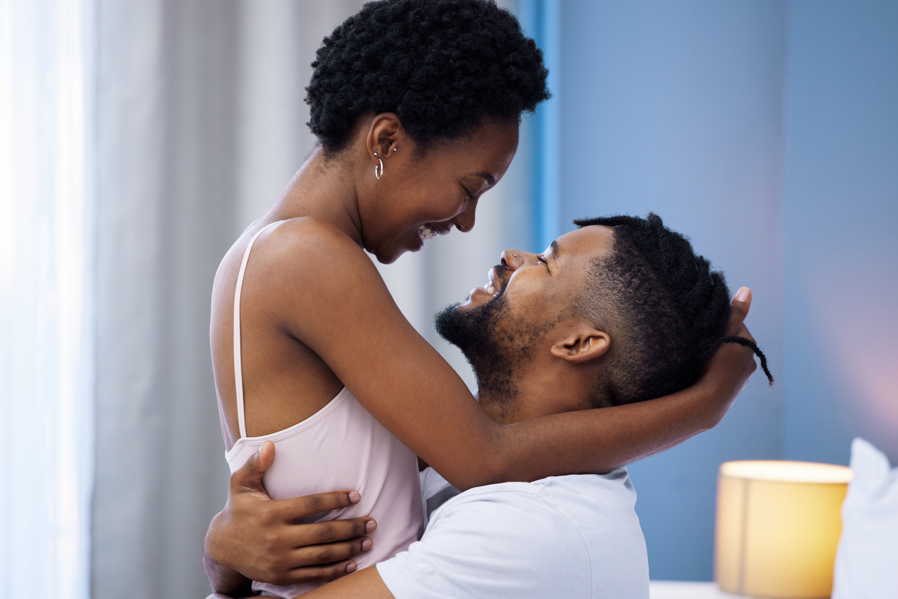 a couple looking at each other in bed