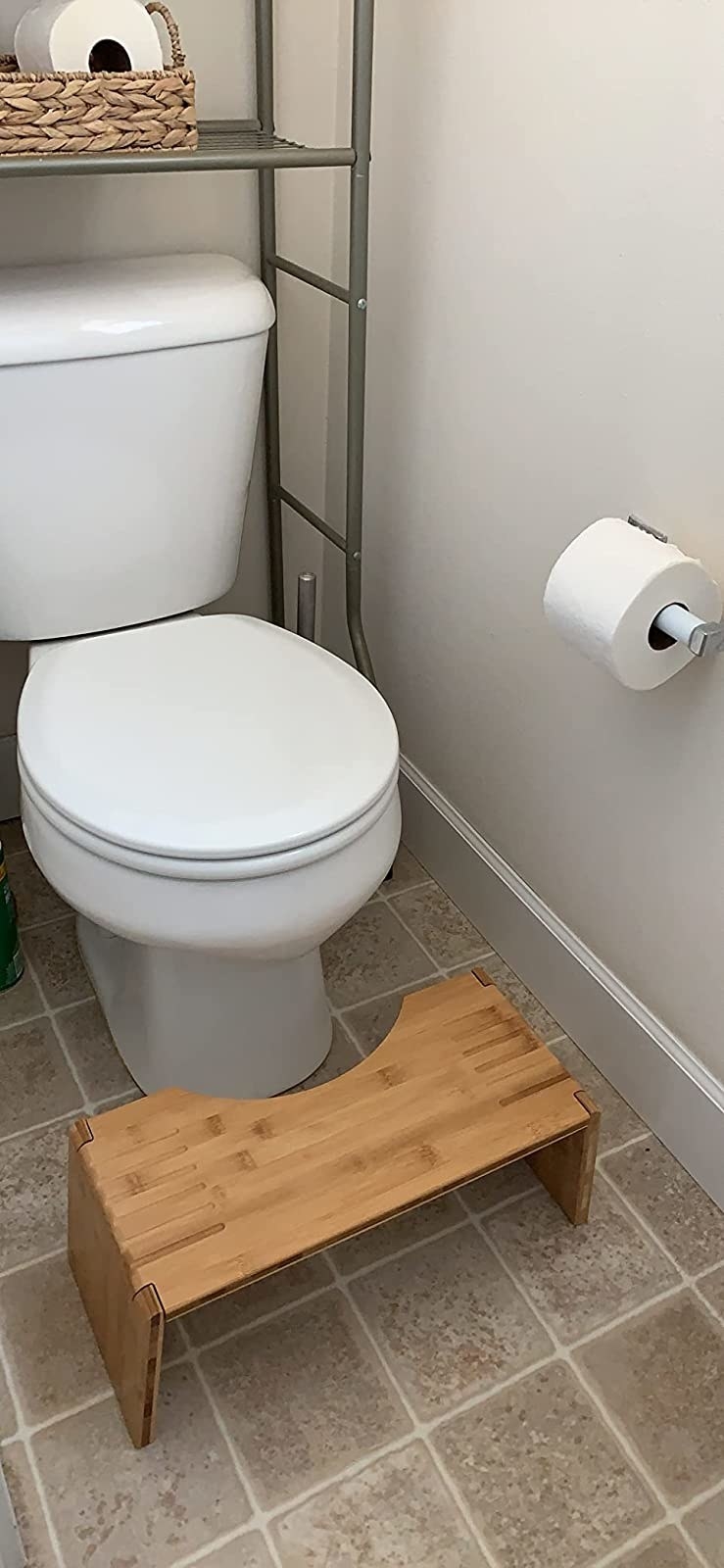 a reviewer photo of the light wood stool in front of a toilet