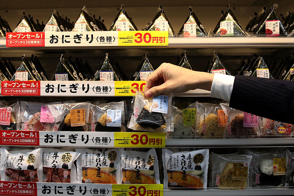 A hand reaching for Japanese onigiri