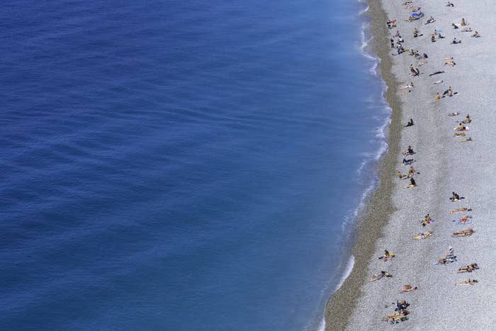 Group of tourists are sunbathing on the beach