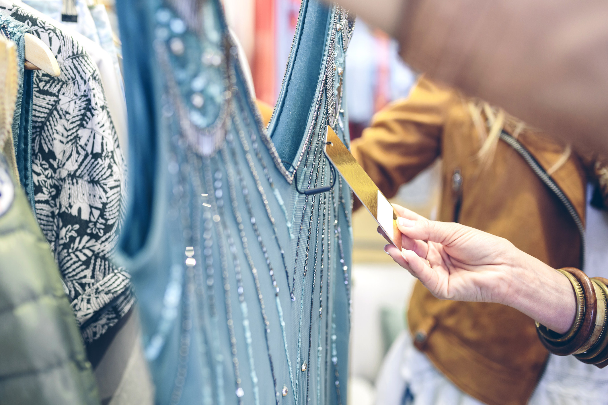 Close-up of woman checking price tag of a dress in a boutique