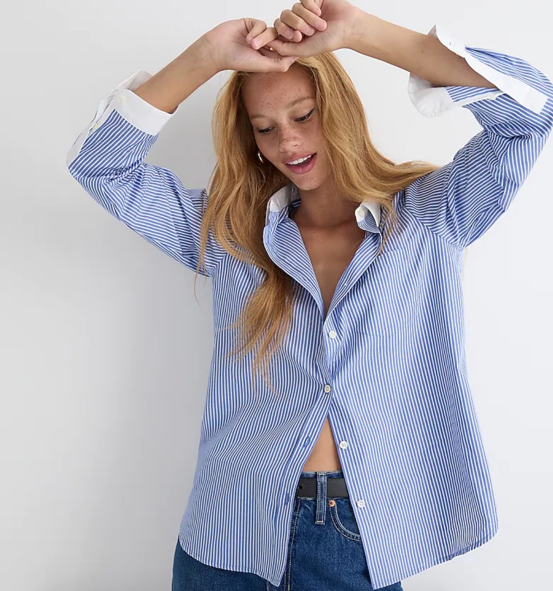 A model wearing a blue and white stripped poplin button up